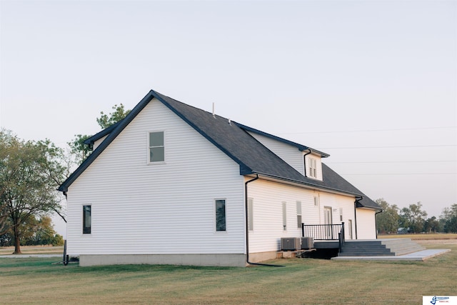 view of home's exterior with a yard and central AC