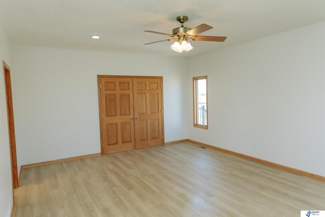 unfurnished bedroom with ceiling fan, light wood-type flooring, and a closet