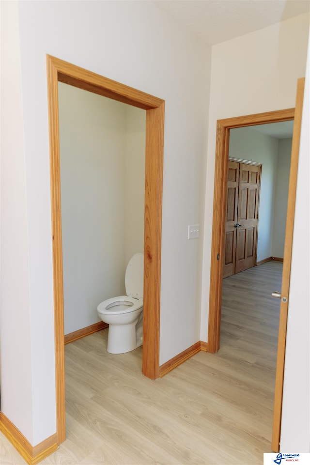 bathroom with hardwood / wood-style floors and toilet