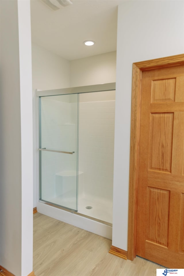 bathroom with wood-type flooring and walk in shower