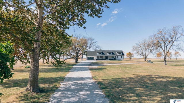 view of front facade featuring a rural view, a garage, and a front yard