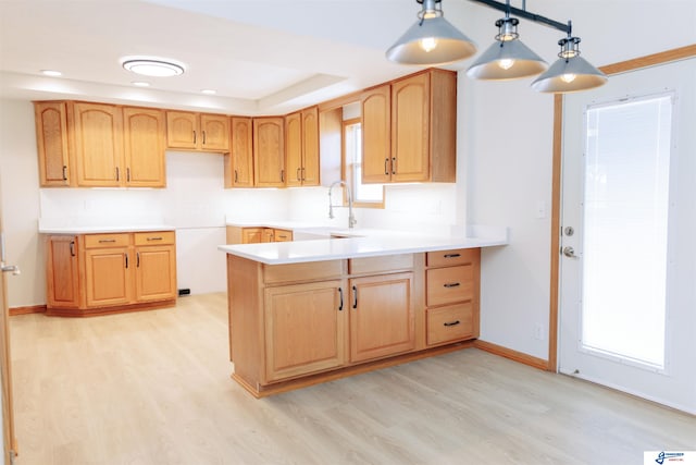 kitchen featuring a wealth of natural light, light hardwood / wood-style flooring, and hanging light fixtures