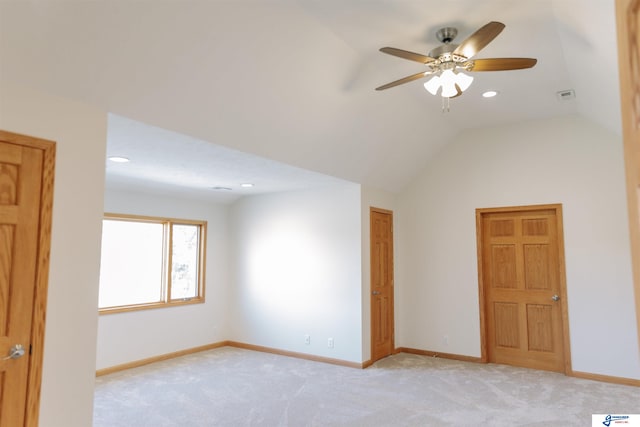 carpeted spare room featuring ceiling fan and vaulted ceiling