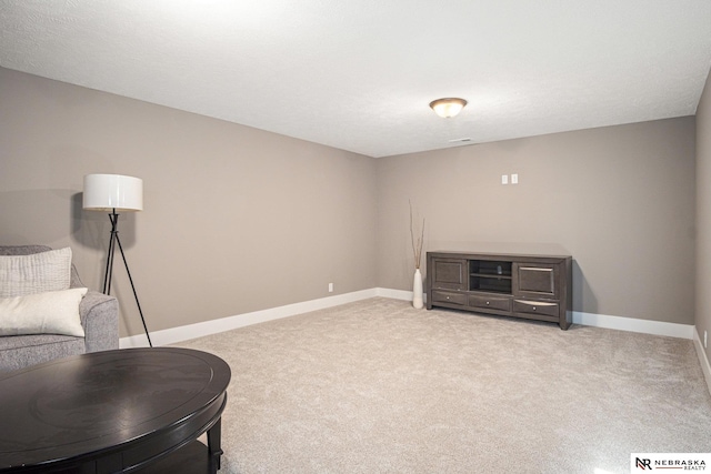 sitting room featuring light carpet and a textured ceiling