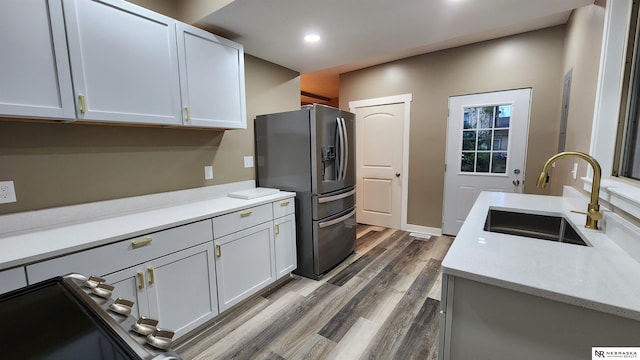 kitchen with white cabinetry, stainless steel fridge with ice dispenser, sink, and dark hardwood / wood-style floors