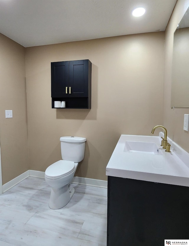 bathroom featuring hardwood / wood-style floors, vanity, and toilet