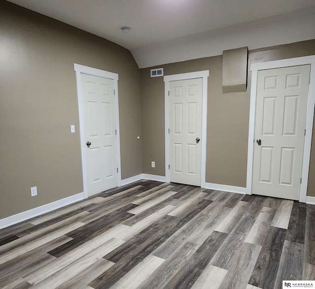 interior space featuring lofted ceiling, a closet, and dark wood-type flooring