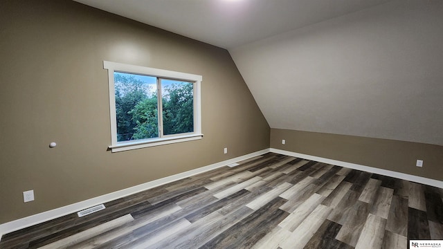 bonus room featuring dark hardwood / wood-style floors and vaulted ceiling