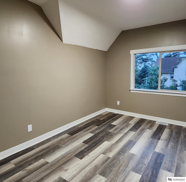 additional living space featuring hardwood / wood-style flooring and vaulted ceiling