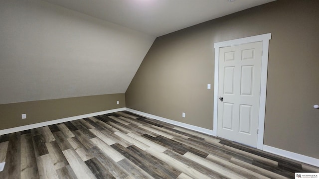 unfurnished room with hardwood / wood-style flooring and vaulted ceiling