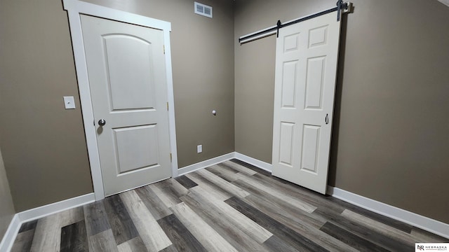 interior space featuring a barn door and wood-type flooring