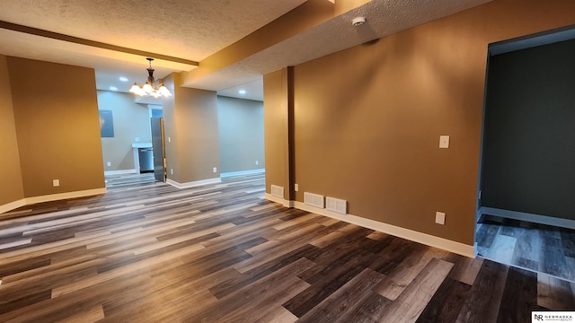 interior space with a notable chandelier, dark hardwood / wood-style flooring, and a textured ceiling