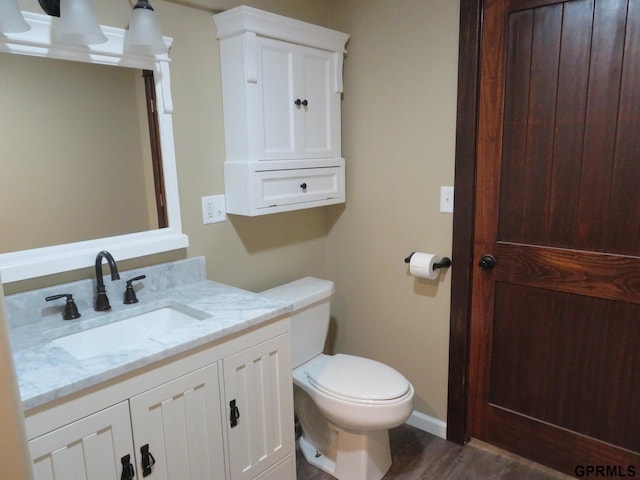 bathroom with vanity, wood-type flooring, and toilet