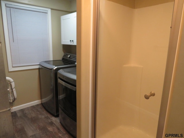 washroom with dark hardwood / wood-style flooring, cabinets, and separate washer and dryer