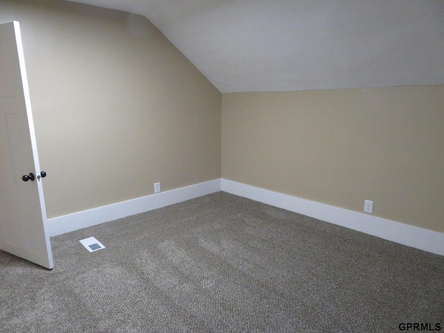 additional living space with carpet floors and vaulted ceiling