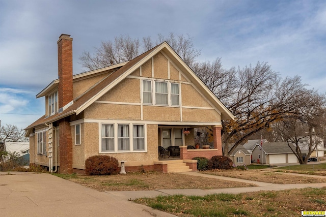 706 1st Ave, Nebraska City, NE 68410 - view of front of property featuring a porch, a chimney, stucco siding, and brick siding
