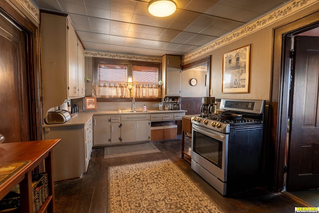 706 1st Ave, Nebraska City, NE 68410 - kitchen with stainless steel gas stove, a sink, light countertops, and dark wood-type flooring