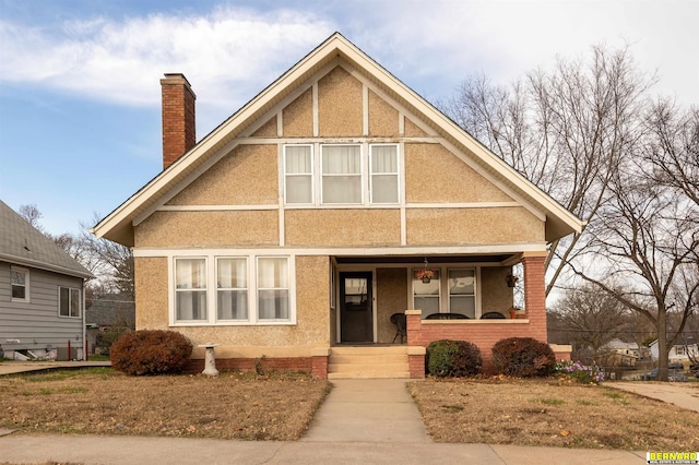 706 1st Ave, Nebraska City, NE 68410 - view of front of house with a porch, a chimney, and stucco siding