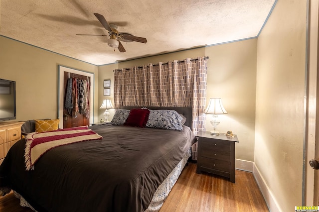 706 1st Ave, Nebraska City, NE 68410 - bedroom with a textured ceiling, wood finished floors, baseboards, ceiling fan, and a closet