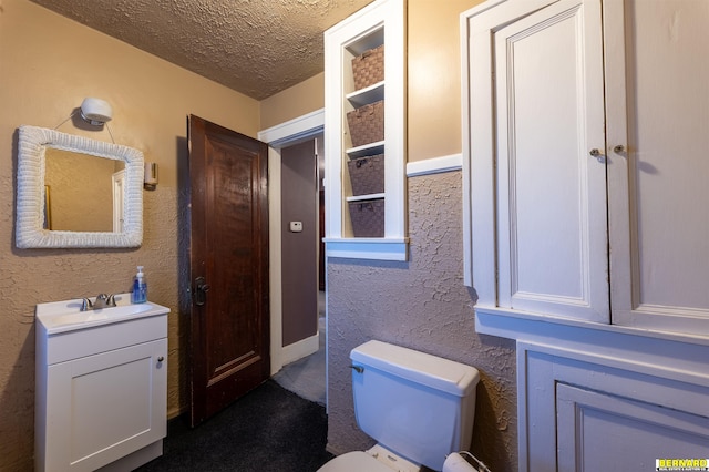 706 1st Ave, Nebraska City, NE 68410 - bathroom with a textured ceiling, vanity, toilet, and a textured wall