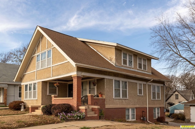 706 1st Ave, Nebraska City, NE 68410 - view of front of home with covered porch, stucco siding, roof with shingles, and brick siding