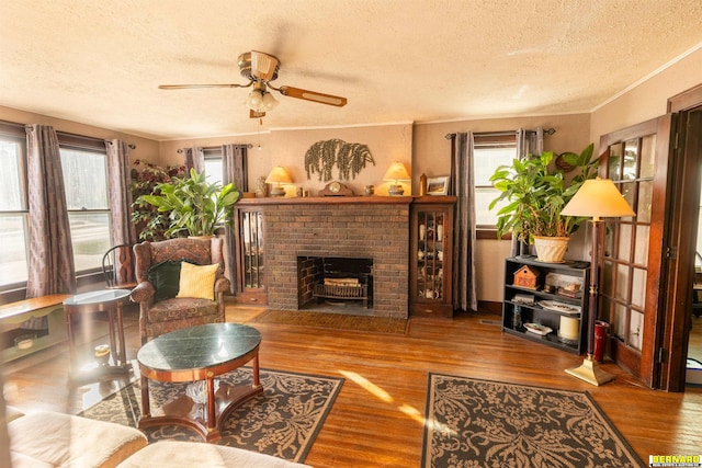 706 1st Ave, Nebraska City, NE 68410 - living room with a textured ceiling, ceiling fan, wood finished floors, a fireplace, and crown molding