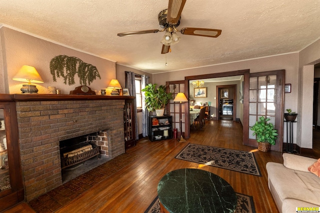 706 1st Ave, Nebraska City, NE 68410 - living room featuring a textured ceiling, a brick fireplace, a ceiling fan, wood-type flooring, and ornamental molding