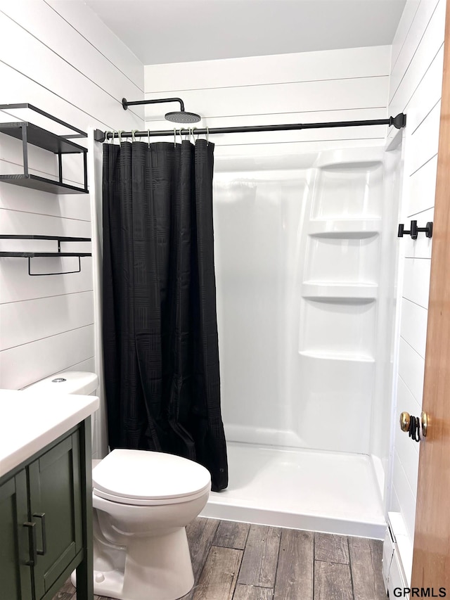 bathroom with a shower with curtain, vanity, hardwood / wood-style flooring, toilet, and wood walls