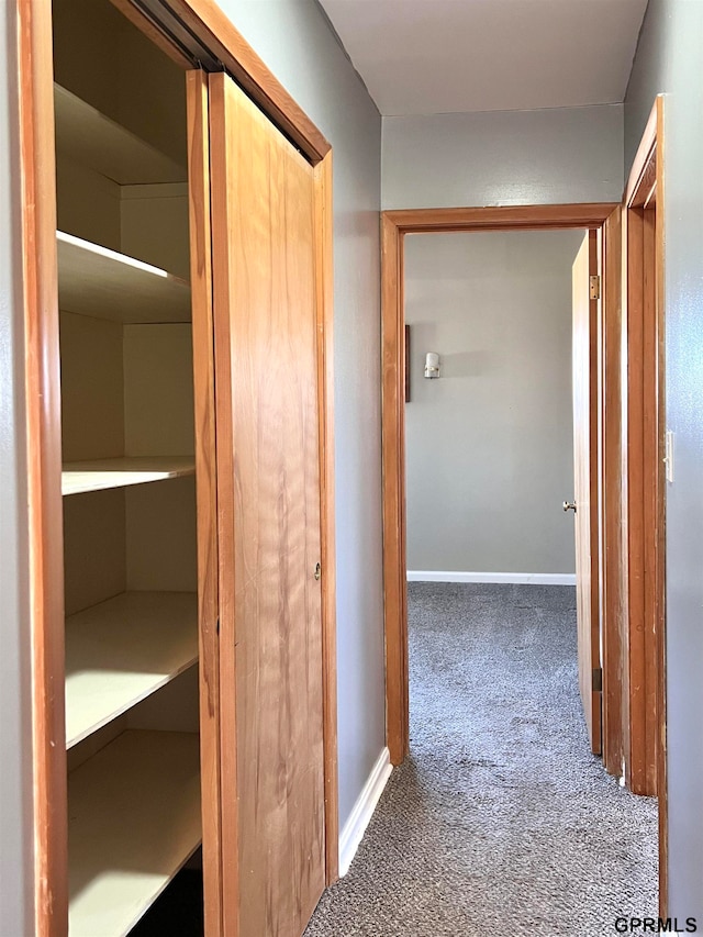 hallway with dark colored carpet