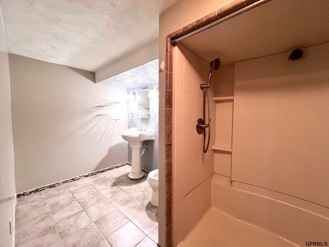 bathroom with a shower, tile patterned floors, a textured ceiling, and toilet