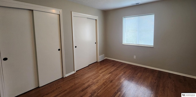 unfurnished bedroom with dark hardwood / wood-style flooring