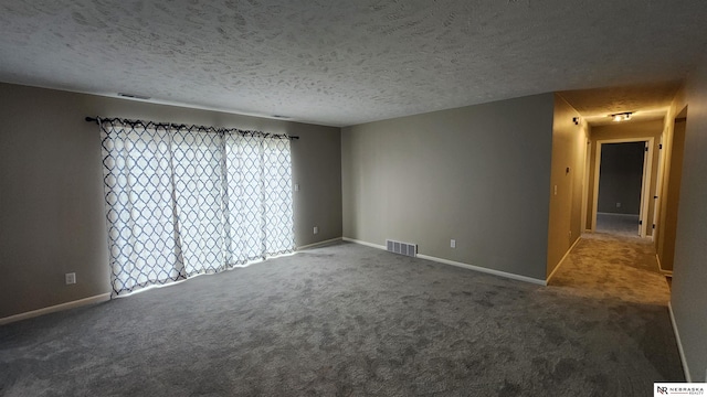 unfurnished room with carpet floors and a textured ceiling