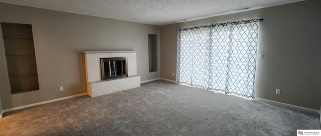 unfurnished living room featuring a fireplace, carpet floors, and a textured ceiling