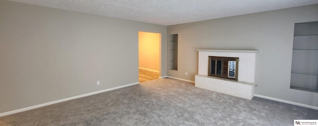 unfurnished living room with carpet, a textured ceiling, and a fireplace