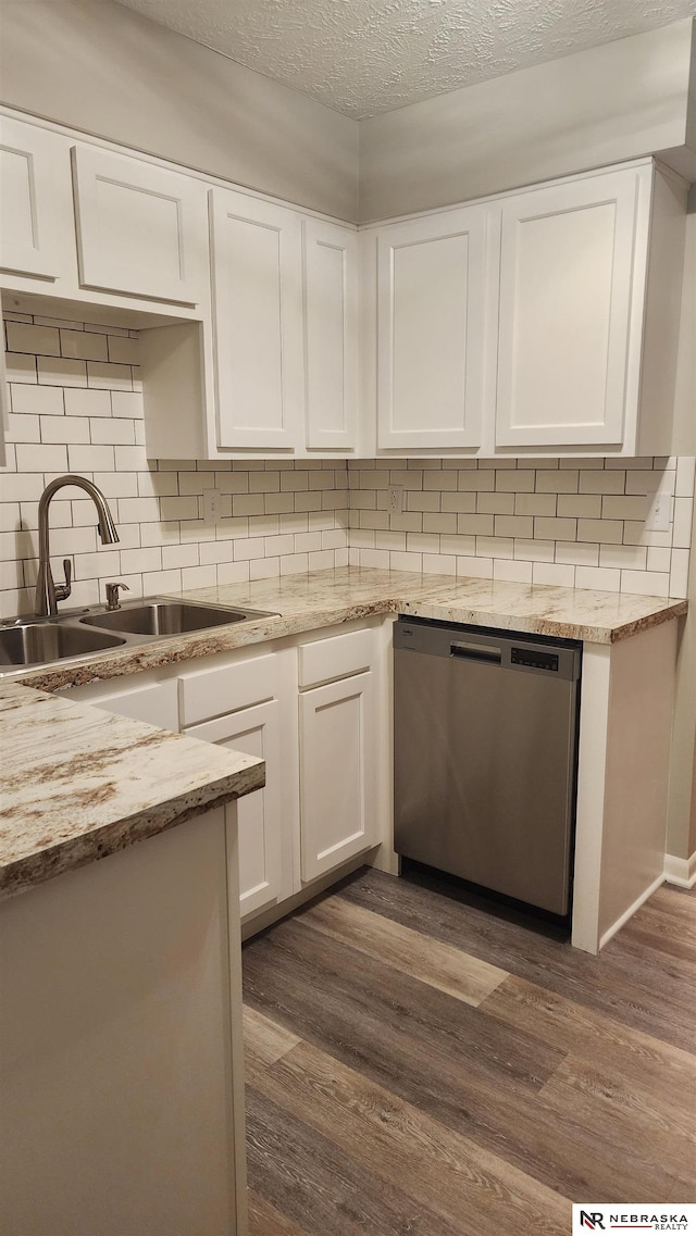 kitchen with stainless steel dishwasher, a textured ceiling, sink, white cabinets, and dark hardwood / wood-style floors