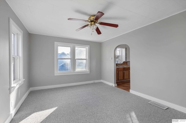 empty room with ceiling fan, sink, and carpet floors