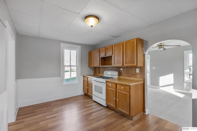 kitchen featuring ceiling fan, light wood-type flooring, and white gas range