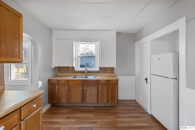 kitchen featuring a drop ceiling, white refrigerator, dark hardwood / wood-style flooring, and sink