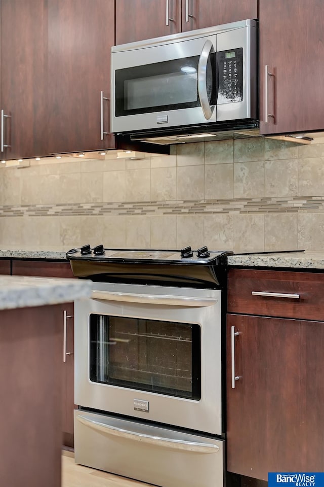 kitchen featuring decorative backsplash, light stone countertops, and stainless steel appliances