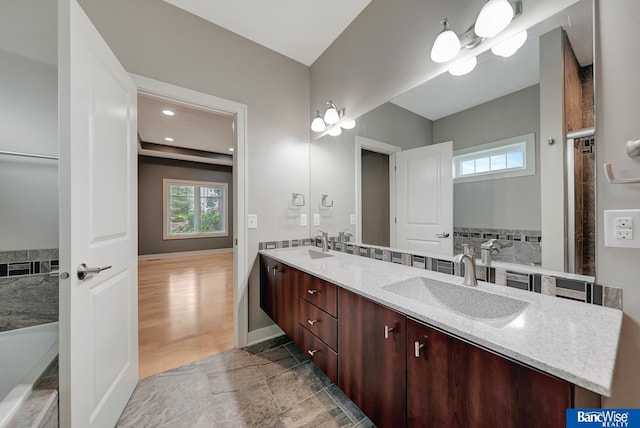 bathroom with a bathing tub, vanity, and wood-type flooring