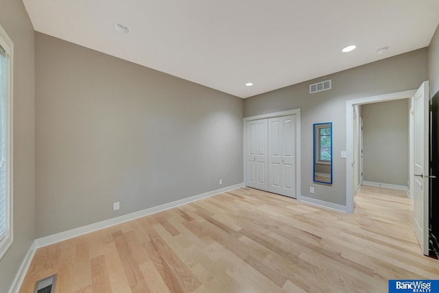 unfurnished bedroom with a closet and light hardwood / wood-style flooring