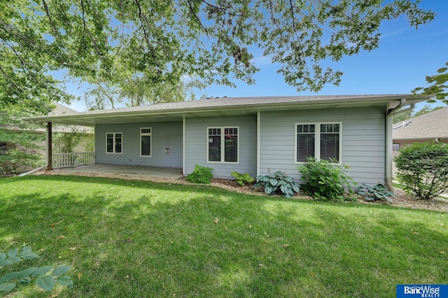 back of property with a yard and a patio