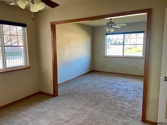 carpeted spare room with ceiling fan and a healthy amount of sunlight