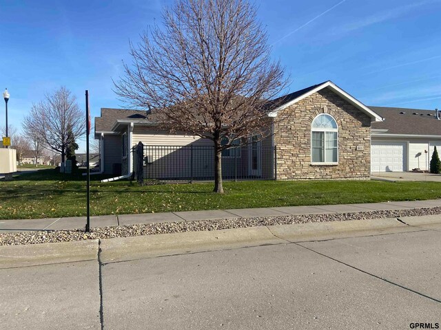 view of side of property with a garage and a lawn