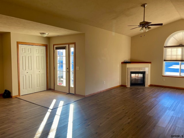 unfurnished living room featuring ceiling fan, light wood-type flooring, a wealth of natural light, and a premium fireplace