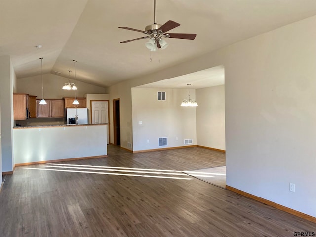 unfurnished living room with vaulted ceiling, ceiling fan with notable chandelier, and dark hardwood / wood-style floors