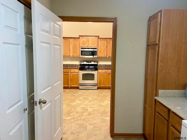 kitchen featuring stone countertops and white electric stove