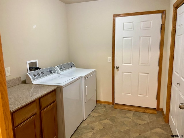 laundry room with washing machine and dryer and cabinets