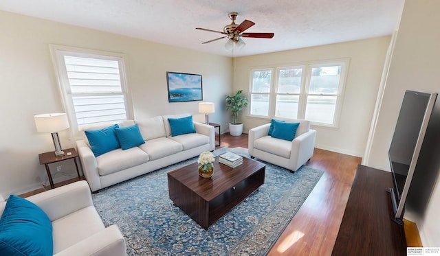 living room featuring dark hardwood / wood-style floors, plenty of natural light, and ceiling fan