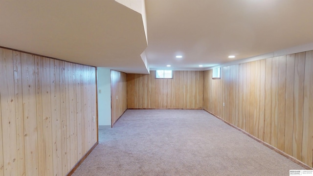 basement with wooden walls and light colored carpet